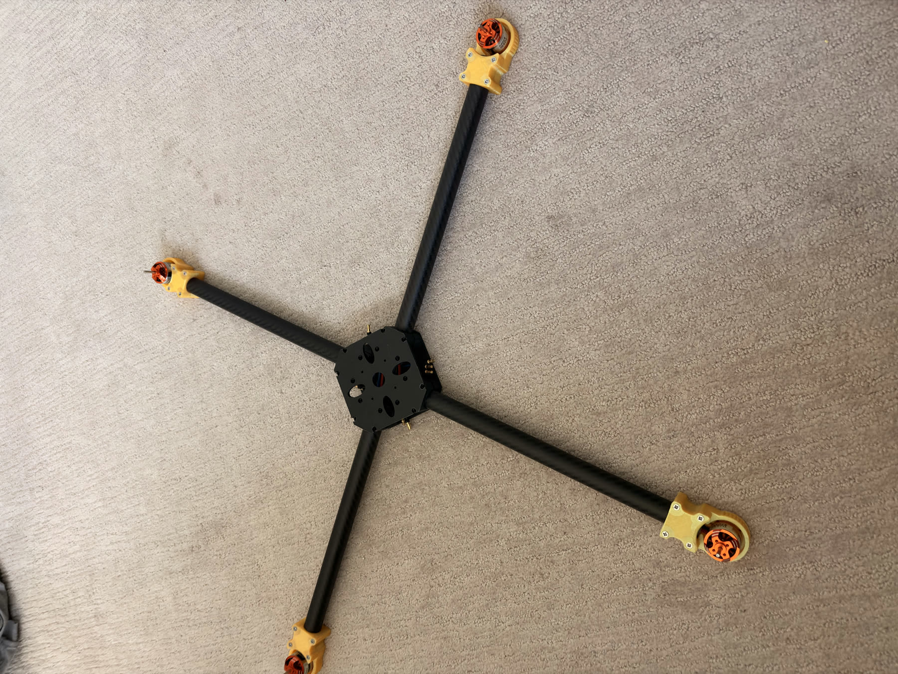 The dry-fit carbon-fiber quadcopter frame with four arms and motors installed.